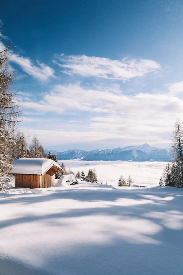 cabane dans un paysage enneigé montagnes au loin