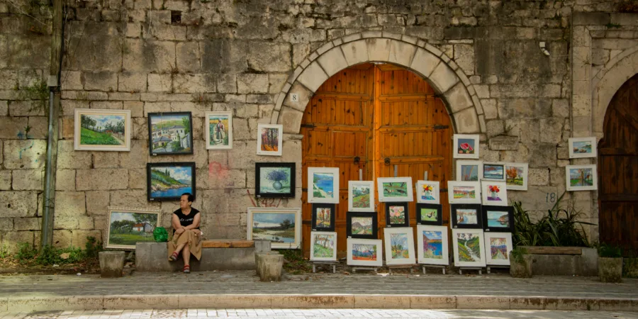 une femme assise sur un banc devant un immeuble