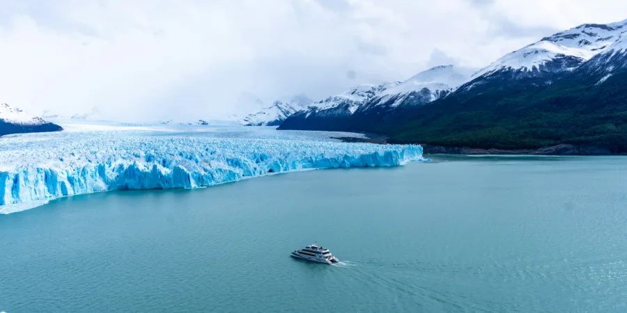 un bateau navigue sur des eaux glacees pres dun enorme glacier